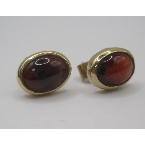 180 - Pair of cabouchon garnet earrings in yellow metal settings, one of the retainers stamped 375. With a... 