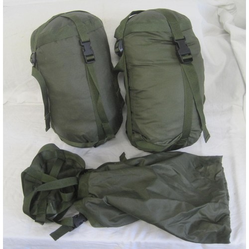 126 - Two military style warm weather sleeping bags in holders, and a spare holder