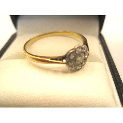 2 - An antique daisy design diamond cluster ring, the centre stone an old cut diamond surrounded by eigh... 