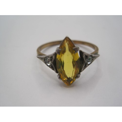 15 - A dress ring set with a marquise cut yellow stone to the centre (might be glass) with a small white ... 