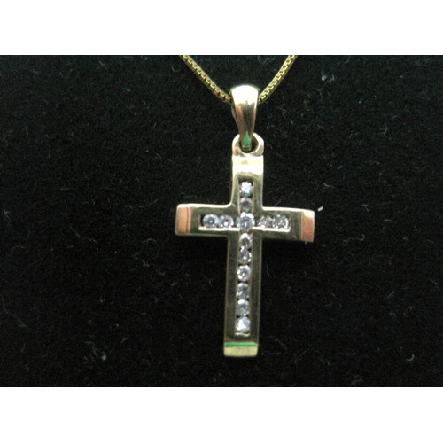 17 - A 9 carat imported gold cross pendant set with thirteen small channel-set brilliant cut diamonds, an... 