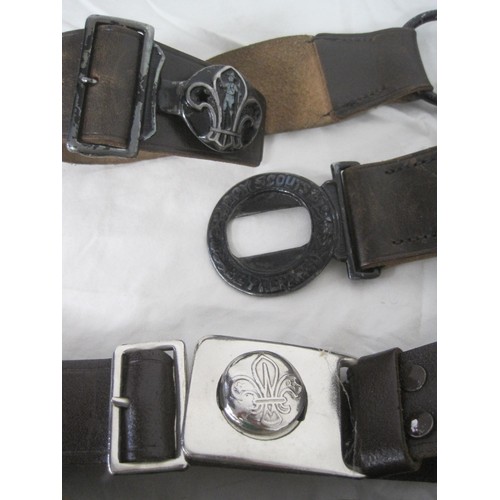 76 - An assortment of Boy Scouts leather belts with metal buckles, all of some age, plus a leather harnes... 