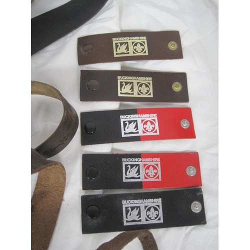 76 - An assortment of Boy Scouts leather belts with metal buckles, all of some age, plus a leather harnes... 