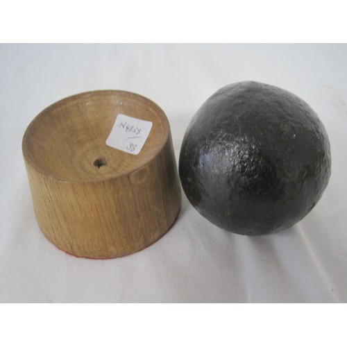 4 - A round shot iron cannon ball (approximately 7cms diameter) seated on a hardwood stand.