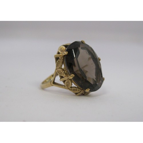 186 - A 9 carat gold ladies dress ring set with a large (about 15mm x 11mm) smoky colour faceted stone, Br... 