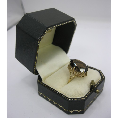 186 - A 9 carat gold ladies dress ring set with a large (about 15mm x 11mm) smoky colour faceted stone, Br... 