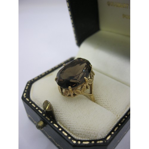 186 - A 9 carat gold ladies dress ring set with a large (about 15mm x 11mm) smoky colour faceted stone, Br... 