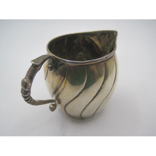 180 - A small white metal cream jug with repousse and engraved decoration, height about 5.5cm, approx. 51g... 