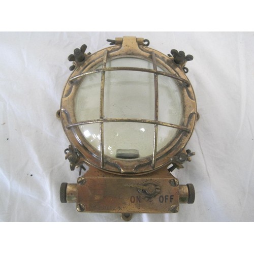 182 - A small brass marine bulkhead lamp with lens protector and integral switch, marked to rear BMAC LTD ... 