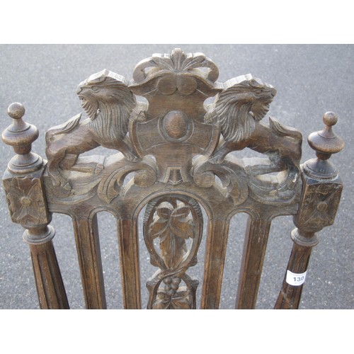 130 - An antique carved oak hall chair, height of backrail 113cm, carved with leaves, lions and shield. A/... 