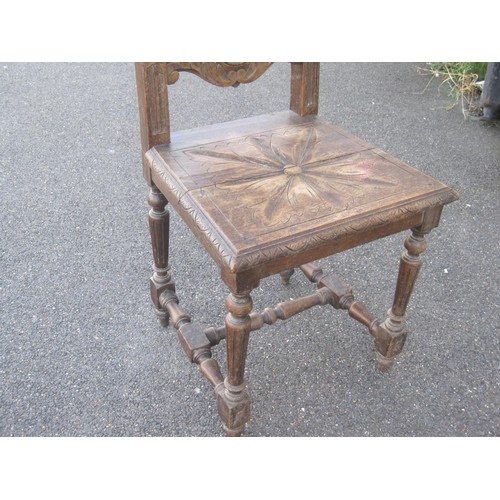 130 - An antique carved oak hall chair, height of backrail 113cm, carved with leaves, lions and shield. A/... 