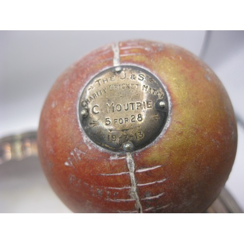 262 - An antique cricket ball on a wooden stand, the ball with a silver inset marked 'The J & S Charity Cr... 