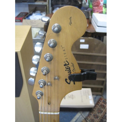 63 - A Squire Strat by Fender Affinity Series six-string electric guitar, with a stand and a Park G10 amp... 