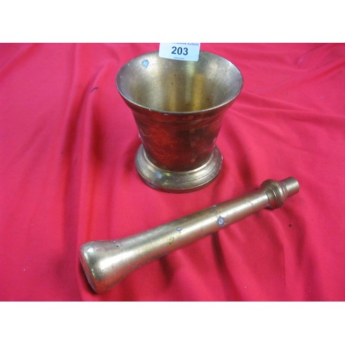 7 - A brass mortar and pestle. Height of mortar 10cm, diameter at rim 10.5cm, indistinct engraved marks ... 