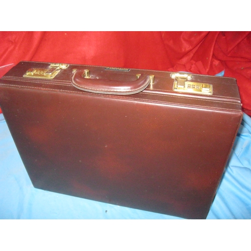 27 - A vintage attache case with combination locks, leather finish.