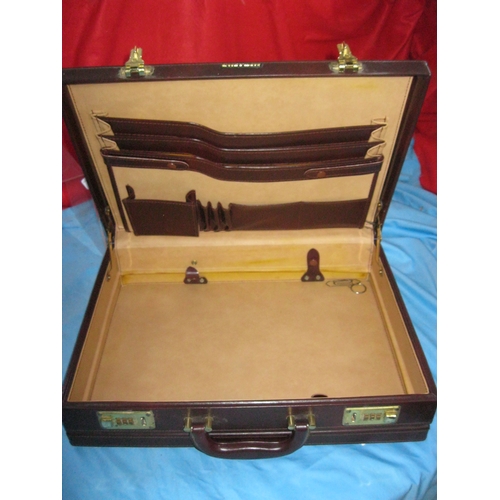 27 - A vintage attache case with combination locks, leather finish.