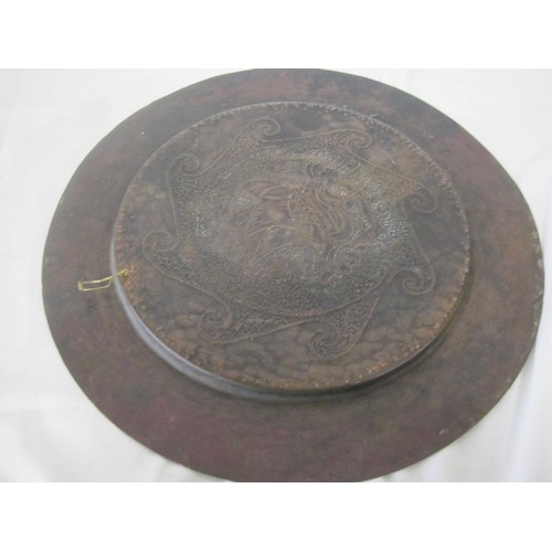 37 - A Newlyn style circular copper dish with embossed and hammered decoration of ship and stylized waves... 