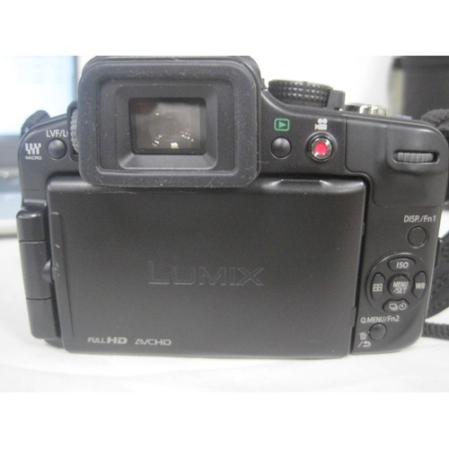 240 - Two Panasonic Lumix digital cameras with lenses, Nissin flash, and accessories, in a camera bag. (Th... 