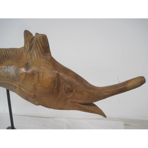 33 - A carved wooden figure of a spearfish or similar, raised on a metal pole and mounted on a rustic woo... 