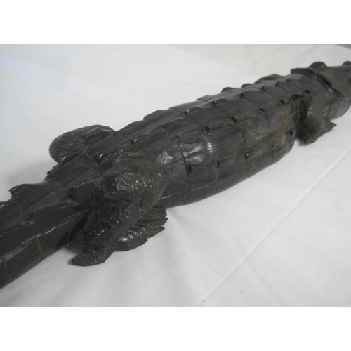 32 - An ebonised carved hardwood figure of a crocodile, length 94cm