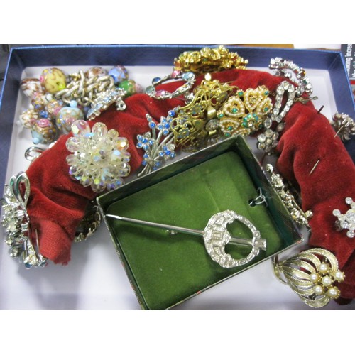 67 - A box of costume jewellery including a kilt pin, a Swarovski brooch, an interesting enamel finished ... 