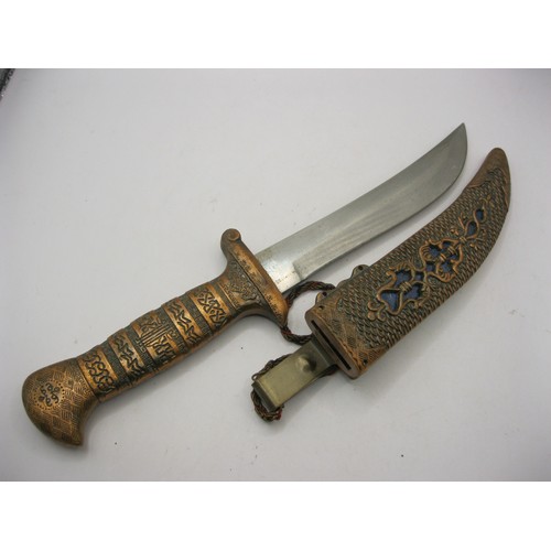 27 - An ornately marked Middle Eastern or Indian dagger in copper or brass finish with stainless steel bl... 