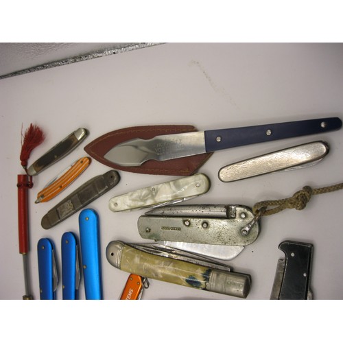 32 - A tin containing a quantity of penknives including a folding knife, fork and spoon set, a military s... 