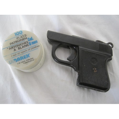 377 - A vintage starting pistol with a tin of starting blanks, works