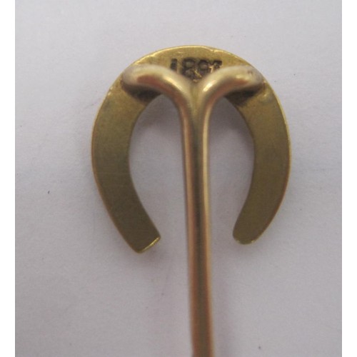 153 - A gold horseshoe stick pin, stamped 18CT, length about 56mm, approx. 1.7g. Acid test suggests 14 car... 