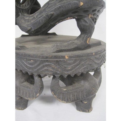 148 - A heavily carved hardwood planter, the stand formed of dragons