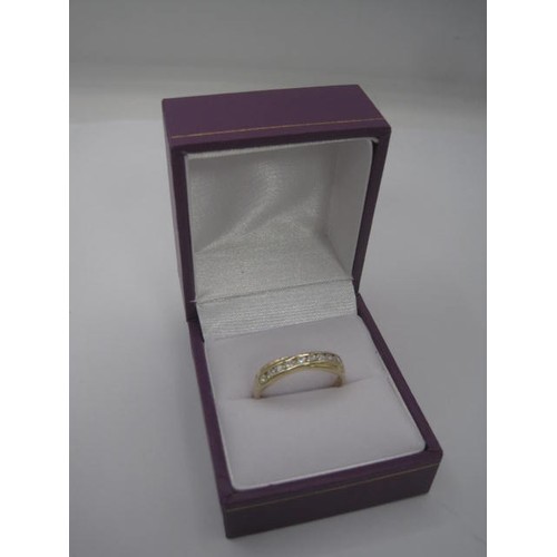 175 - A 9 carat gold ring set with a row of nine faux white stones, ring size P, gross weight approx. 1.9g... 