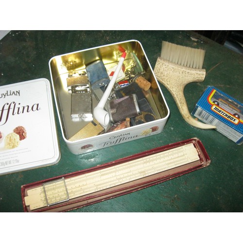 173 - A tin of interesting items including lighters, a clay pipe, slide rule, etc