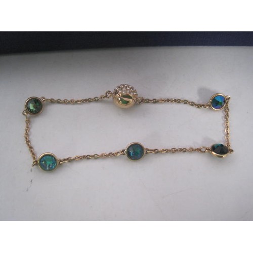 48 - A Swarovski gold-tone costume bracelet with blue, green and white crystals and magnetic clasp, and a... 