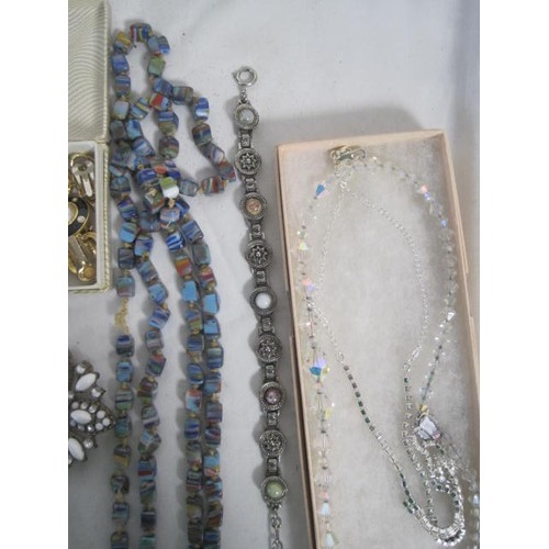 49 - An assortment of costume jewellery, including a necklace of swirled glass cube beads, a pair of gold... 