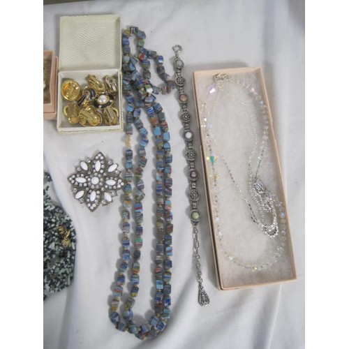 49 - An assortment of costume jewellery, including a necklace of swirled glass cube beads, a pair of gold... 