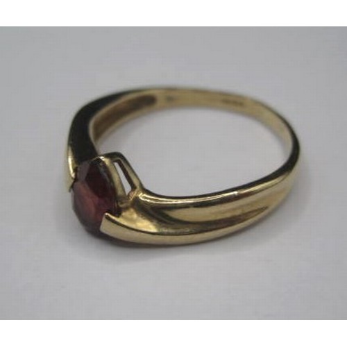 186 - A 9ct gold ring with a lovely coloured garnet set in an offset double teist setting. Stone size 4mm ... 