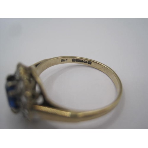 263 - A 9 carat gold dress ring set centrally with a round blue stone surrounded by twelve small white sto... 