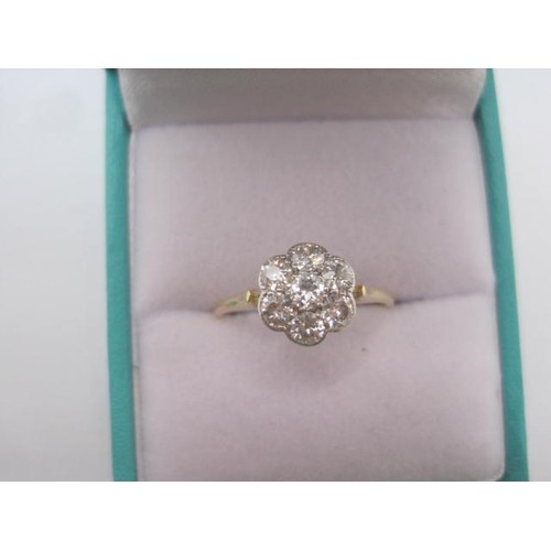 256 - A pretty and eye-catching gold seven-stone diamond ring in a foliate setting. Ring size N, gross wei... 