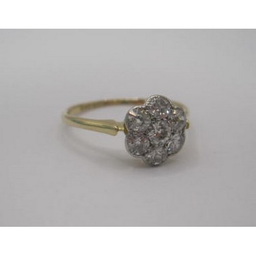 256 - A pretty and eye-catching gold seven-stone diamond ring in a foliate setting. Ring size N, gross wei... 