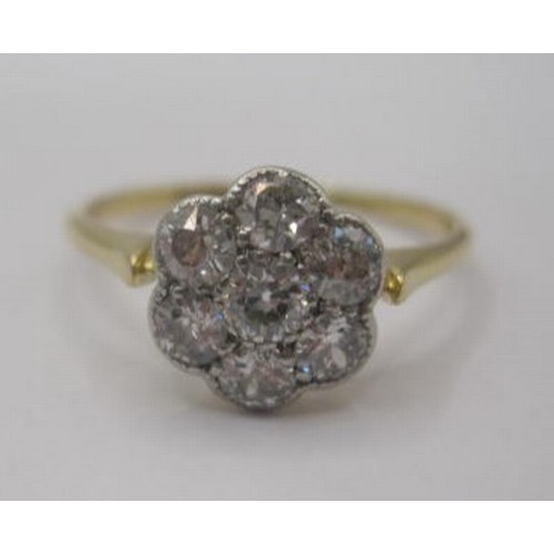 256 - A pretty and eye-catching gold seven-stone diamond ring in a foliate setting. Ring size N, gross wei... 