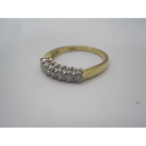 253 - An 18 carat gold seven stone diamond ring. A row of seven diamonds in claw setting. Ring size R, gro... 