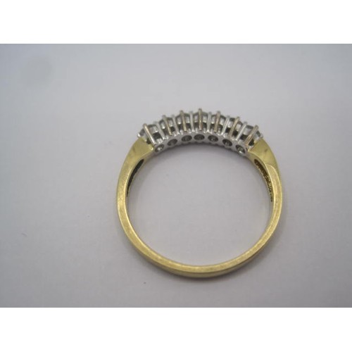 253 - An 18 carat gold seven stone diamond ring. A row of seven diamonds in claw setting. Ring size R, gro... 