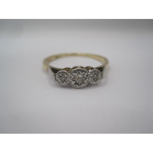 257 - An 18 carat gold ring with a row of three small diamonds in illusion setting, ring size Q, gross wei... 