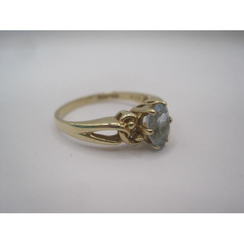 252 - A 9 carat gold ring set with a pear cut aquamarine in a pierced and scrolled shoulder setting. Ring ... 