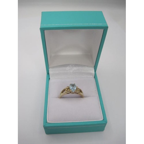 252 - A 9 carat gold ring set with a pear cut aquamarine in a pierced and scrolled shoulder setting. Ring ... 