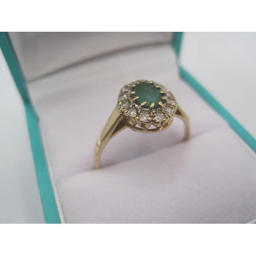 265 - A 9 carat gold emerald and diamond ring. The oval cut emerald (estimated at 5.5mm x 4.5mm) set in a ... 