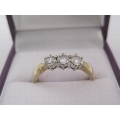 260 - A 9 carat gold ring set with a row of three diamonds in claw settings, ring size Q/R, gross weight o... 