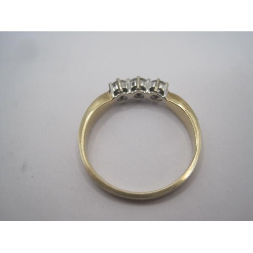 260 - A 9 carat gold ring set with a row of three diamonds in claw settings, ring size Q/R, gross weight o... 