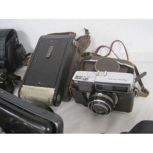 23 - A box of cameras - an a/f spares or repair Olympus OM1 (mechanism feels completely inoperative) with... 