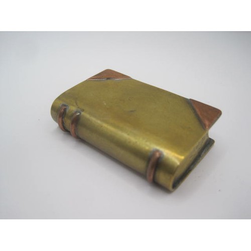 289 - A WW1 trench art lighter in the form of a miniature book. Made of bits of brass and copper. The spin... 